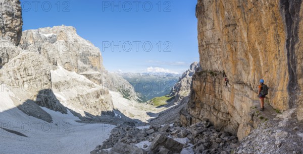 Mountaineers on the Bocchette Centrale band trail, via ferrata in the Brenta Mountains, rock wall,