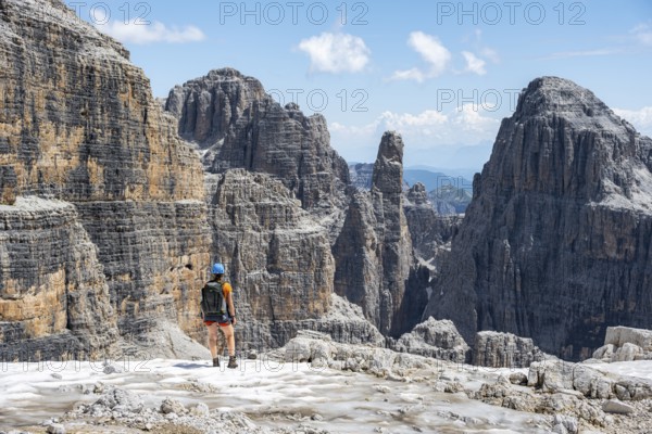 Hikers on the Sentiero Brentari hiking trail in front of cliffs, Brenta Mountains, Brenta-Adamello