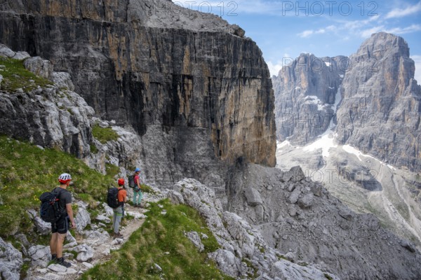 Three mountaineers on a hiking trail, rocky mountain landscape, Via Ferrata SOSAT via ferrata,