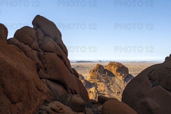 Dramatic rock formations with views of vast desert landscape under clear skies in Spitzkoppe,