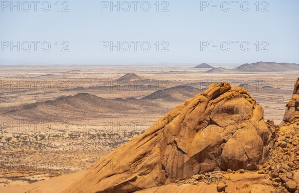 View of extensive desert landscape and distinctive rock formations on the horizon, Spitzkoppe,