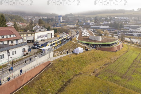 Panoramic view of a train with people in a hilly district during an event, opening of the Hermann