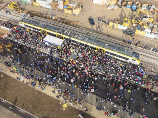 Dense crowd around a train on a construction site, taken from above, opening of the Hermann Hesse
