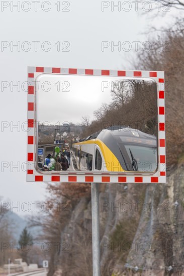 A train in the mirror on a railroad track in a mountainous area, opening of the Hermann Hesse