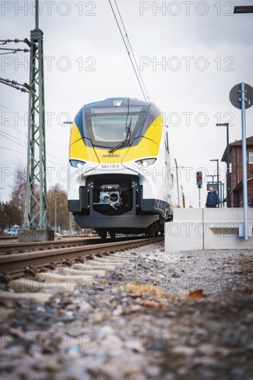 Modern locomotive at close range on railway tracks under grey skies, opening of the Hermann Hesse