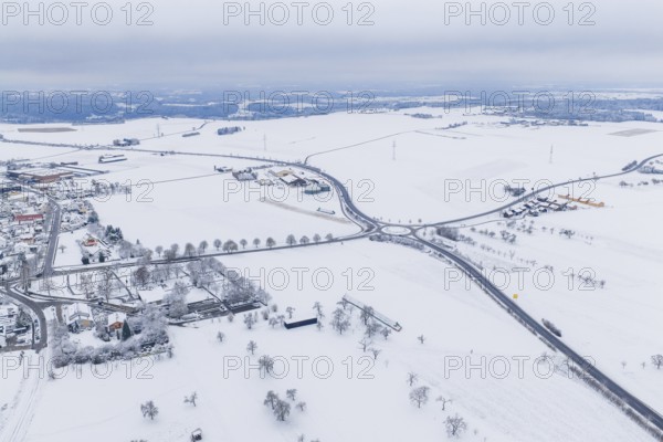 Snow-covered intersection in the middle of a vast winter landscape with surrounding villages,