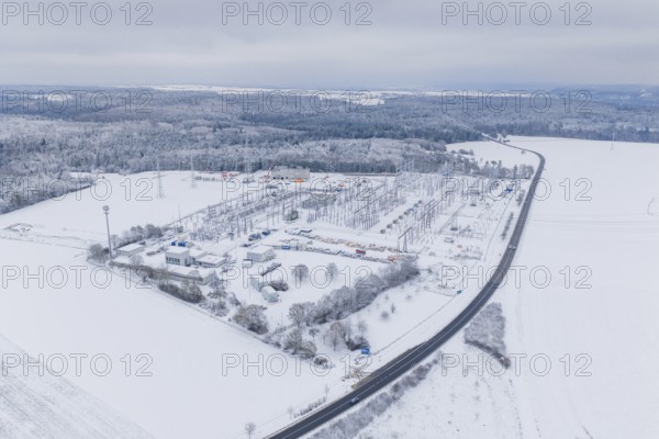 Aerial view of a snowy substation and a wide road in a winter landscape, substation, Jettingen,