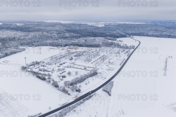 Snowy substation and road in the midst of a winter landscape with thick forests, substation,