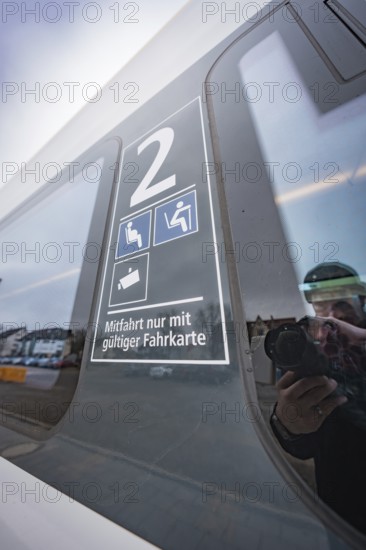 Window reflection with information on valid ticket and seats, battery electric train Siemens Micro