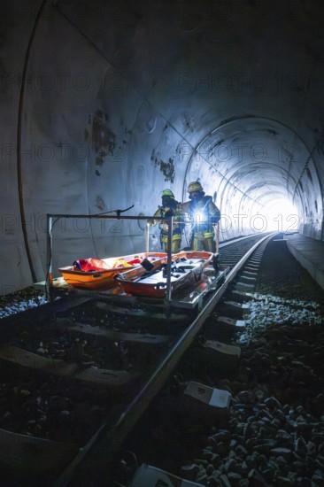Firefighters stand on an ambulance in a tunnel, equipped for a mission, fire drill on the