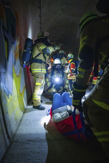 Firefighters provide first aid to an injured person in a dark tunnel, fire drill on the