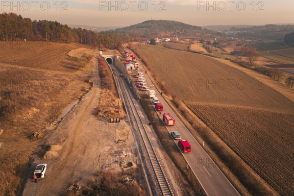 Aerial view with emergency vehicles next to a tunnel and fields in the background, fire drill at