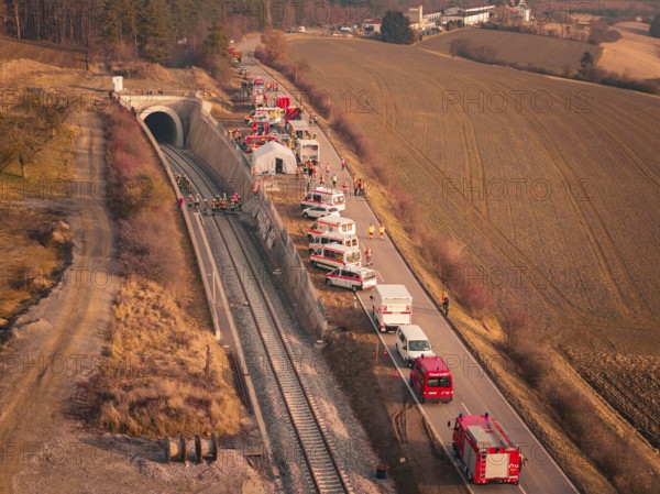 Aerial view of emergency vehicles along a tunnel next to a railway line, fire drill at the
