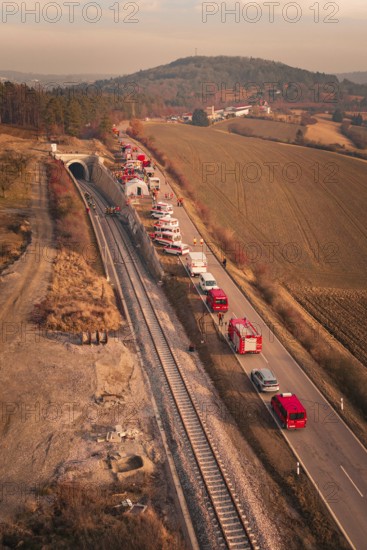 Aerial view of a scenario with emergency vehicles along a tunnel and a road, fire drill at the