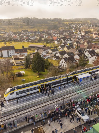 Train stops in a city, people flock onto the platform surrounded by buildings, opening of the
