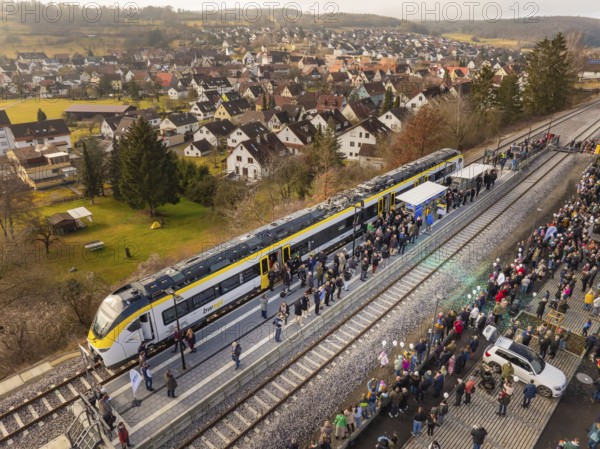 Arrival of the train, greeted by people, in a small village surrounded by nature, opening of the