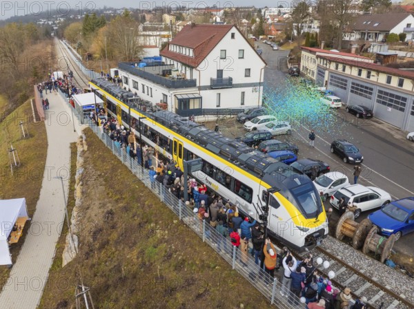 Zug at an event with people and rain of confetti, surrounded by vehicles and buildings, opening of