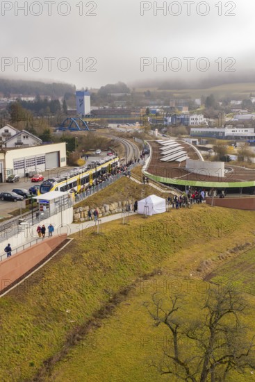 A large crowd gathers at a station area in a hilly landscape, opening of the Hermann Hesse Railway,