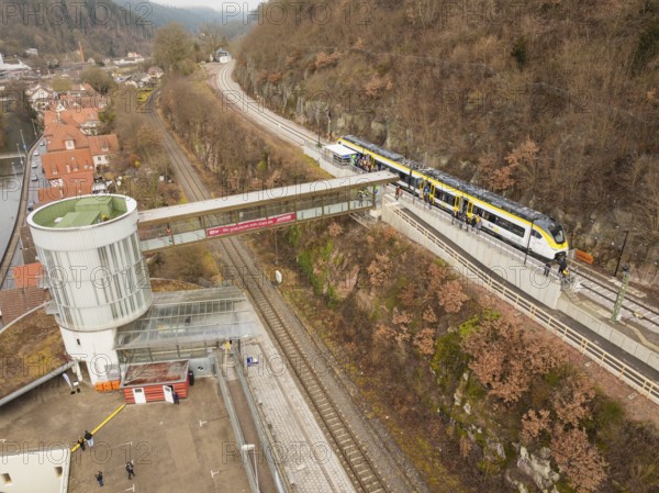 Landscape view of a railway station with bridge, hills and city in the background, opening of the