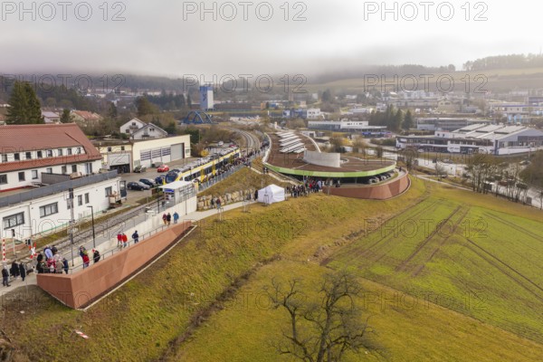 Station from above with surrounding urban landscape and people, drafty morning sky, opening of the