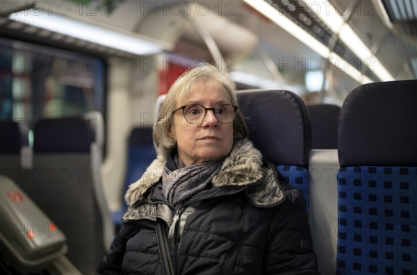 Elderly woman, portrait, thoughtful, glasses, gray hair, coat, scarf, winter clothes, sitting in