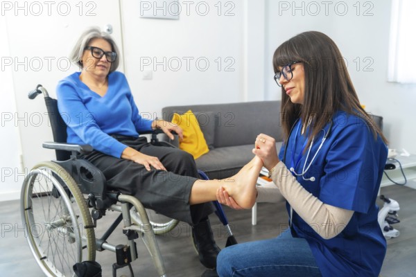 Professional caregiver providing a foot examination and physical therapy to an elderly woman