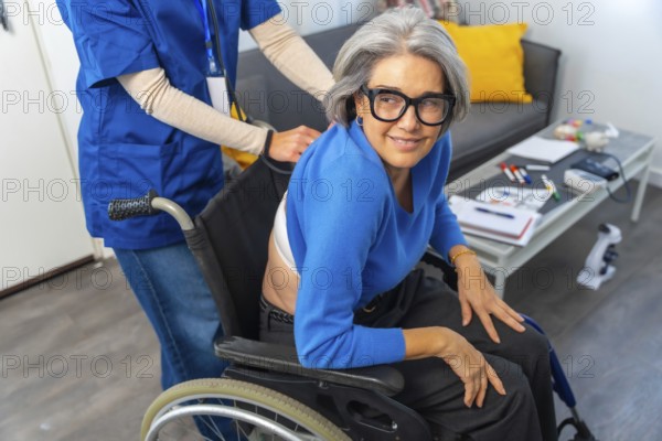 Senior woman in a wheelchair smiling and looking at camera while a professional nurse or caregiver