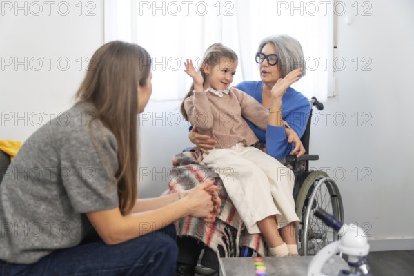 Family members connecting during a visit, with a senior woman in a wheelchair holding her