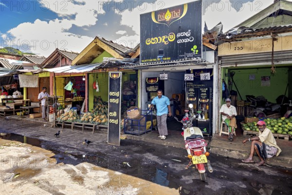 Rural street scene with small shops and people standing on the side of the road, The old market