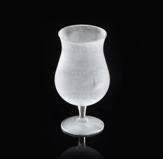 Frosted balloon glass, tulip glass against black background, studio shot