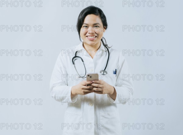 Young asian female doctor holding phone looking at camera isolated, Concept of online medical