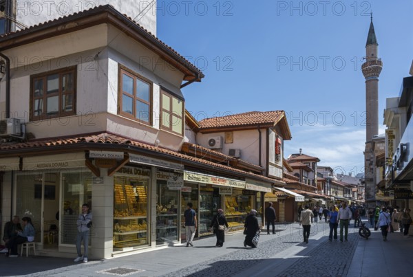 Bustling market street with traditional shops and a minaret in the background, Konya, Central