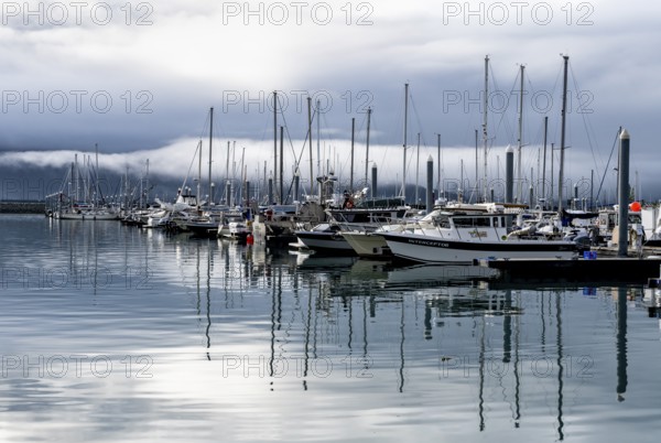 Boats in harbor, cloudy mountain peaks behind, with reflection, Seward, Kenai Peninsula, Alaska,