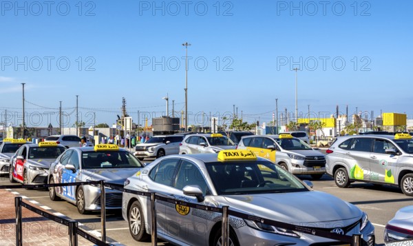 Taxi and hop on hop off buses are waiting for tourists in the cruise terminal parking lot, Abu