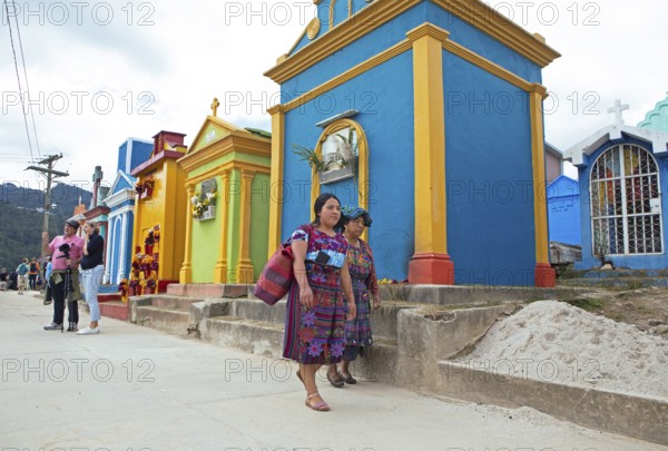 Mayan woman wearing traditional clothing at colorful graves at the cemetery in Chichicastenango,