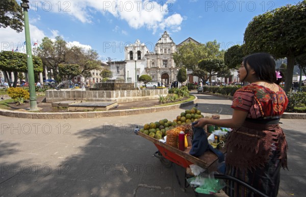Parque Centroamérica or Parque Central, a Mayan woman in traditional dress selling oranges, in the