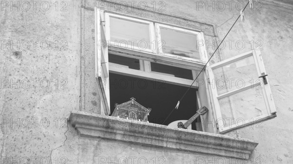 Open window with guitar and empty cage, retro atmosphere, black and white, Bratislava, Slovakia