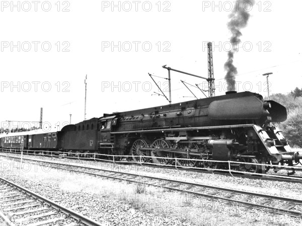 Historic steam locomotive pulls wagons onto tracks, smoke rises, Upper Franconia