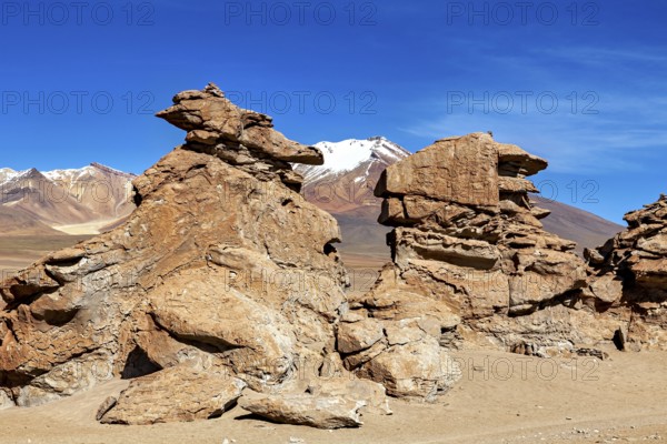 Majestic rock formations in a vast, barren desert landscape under blue skies, The Altiplano