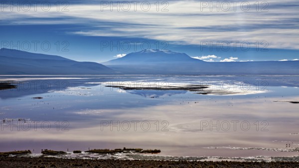 Dramatic cloud formations over a reflecting lake and distant mountain ranges, The Laguna Colorada