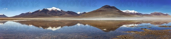 Wide panoramic view of mountains reflecting in the still lake, with snow-capped peaks, The Laguna