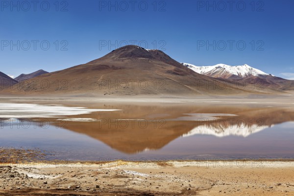 Lonely mountain landscape with reflecting lake and snow-capped peaks under clear skies, Laguna