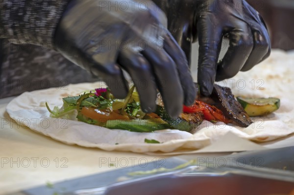 Preparation of falafel with fresh vegetables in a falafel stand in the pedestrian zone, Nuremberg,