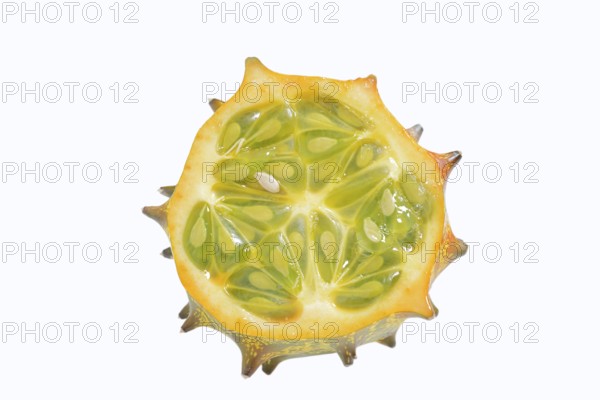 Horned cucumber, kiwano or horned melon (Cucumis metuliferus), sliced fruit on a white background,