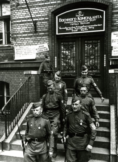 Two Soviet soldiers in front of the administration of the war commander for the district of