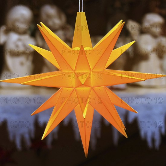 Glowing Christmas star in front of angel figures at the Christmas market, detail, Paderborn,