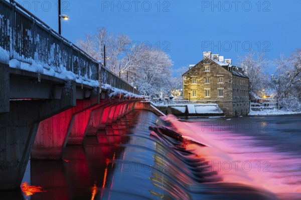 Illuminated Moulin Neuf water flow control dam and walkway over Des Mille-Iles river plus New Mill