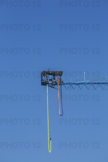 Montreal Bungee Tower installation with dangling long yellow elastic bungee jumping cord and woman