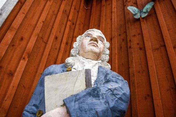 Wooden statue of botanist and founder of the binary nomenclature Carl von Linné with white hair and
