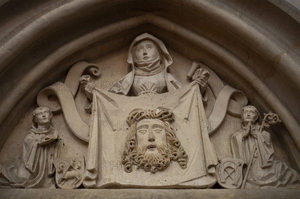 Woman in medieval clothing holding cloth with the face of Christ, stone figure, choir room,